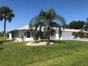 House with palm trees, green lawn, and a white and gray exterior at 431 San Felix St, Punta Gorda, FL 33983