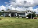 One story home with light blue exterior, two car garage and nicely landscaped yard at 1307 Tidy Ln, Punta Gorda, FL 33983