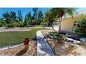 Landscaped front yard with walkway, pond, and mature tropical plants at 27200 San Marino Dr, Punta Gorda, FL 33983