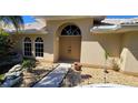Front entrance with double doors and decorative landscaping at 27200 San Marino Dr, Punta Gorda, FL 33983