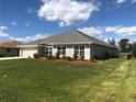One-story home with gray roof and landscaping at 26332 Barranquilla Ave, Punta Gorda, FL 33983
