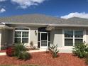 One-story home with gray roof and landscaping at 26332 Barranquilla Ave, Punta Gorda, FL 33983