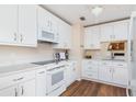 Modern kitchen with white cabinets, quartz countertops and wood flooring at 653 Linden Dr, Englewood, FL 34223