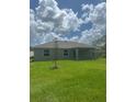 The backyard is a wide green space, with a young tree planted near the home at 5546 Wagon Wheel Dr, North Port, FL 34291