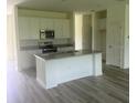 Open kitchen with stainless steel appliances, white cabinetry, and a center island at 5546 Wagon Wheel Dr, North Port, FL 34291