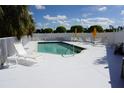 Community pool with patio furniture and umbrellas at 175 Kings Hwy # 923, Punta Gorda, FL 33983