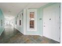 Condo hallway with tiled floors and light teal walls at 5127 Melbourne St # F-204, Port Charlotte, FL 33980