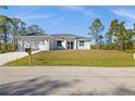 White house with a two-car garage and lush green landscaping at 3297 Swanee Rd, Port Charlotte, FL 33980