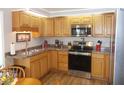 Bright kitchen featuring wood cabinets, stainless steel appliances, and a double sink at 5755 Holiday Park Blvd, North Port, FL 34287