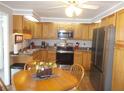 Galley kitchen with wood cabinets and stainless steel appliances at 5755 Holiday Park Blvd, North Port, FL 34287
