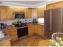 Galley kitchen with wood cabinets and stainless steel appliances at 5755 Holiday Park Blvd, North Port, FL 34287