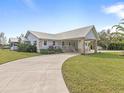 Single-story home exterior with metal roof, stone accents, and a covered porch at 6161 Riverside Dr, Punta Gorda, FL 33982