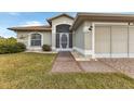 Front entrance with walkway and mature landscaping at 176 Jennifer Dr, Rotonda West, FL 33947
