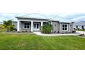 Gray house with white trim, metal roof, and landscaping at 28968 Gin Ln, Punta Gorda, FL 33982