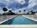 Community pool with white fence and palm trees at 200 Rotonda W Blvd # A4, Rotonda West, FL 33947