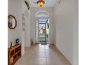 Bright and spacious entryway with tile floors and an open door at 1712 Lastingham Ln, Port Charlotte, FL 33980