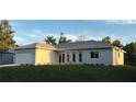 Newly built home with gray roof, light beige walls and a modern stone facade at 22427 Cleveland Ave, Port Charlotte, FL 33954