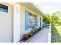 House exterior featuring light-colored siding, blue shutters, and a landscaped walkway at 1333 Song St, Port Charlotte, FL 33952