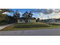 Cute yellow house with solar panels and a well-maintained lawn at 21427 Michigan Ave, Port Charlotte, FL 33952