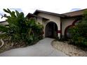 Front entrance with walkway, landscaping, and red accents at 21445 Peachland Blvd, Port Charlotte, FL 33954