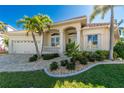 Tan two-story house with tile roof, landscaping, and driveway at 3600 Kassandra Dr, Punta Gorda, FL 33950