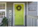 Inviting front door with lime green paint, wreath, and house numbers at 16115 Aralia Dr, Punta Gorda, FL 33955