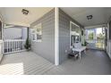 Covered front porch with white bench and small stool at 16115 Aralia Dr, Punta Gorda, FL 33955