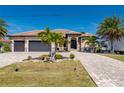 Two-story house with three-car garage, paver driveway, and landscaping at 669 Monaco Dr, Punta Gorda, FL 33950