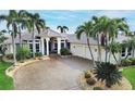 House with tile roof, palm trees, and circular driveway at 1700 Los Alamos Dr, Punta Gorda, FL 33950
