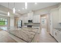 Modern kitchen with white cabinets and expansive granite island at 1863 Waldorf Dr, North Port, FL 34288