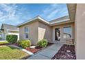 Tan house exterior with landscaped walkway and entrance at 24275 Buckingham Way, Punta Gorda, FL 33980