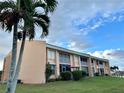 Condo building with balconies, ground level patio, and palm trees at 1354 Rock Dove Ct # A202, Punta Gorda, FL 33950