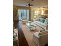 Spacious living room featuring hardwood floors, comfy seating, and large windows at 17434 Boca Vista Rd # 1006, Punta Gorda, FL 33955