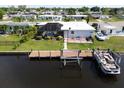 Aerial view of canal-front home with private dock, boat, and pool at 136 Godfrey Ne Ave, Port Charlotte, FL 33952