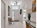 Bright entryway with tiled floor, bench, and mirror at 24055 Buckingham Way, Punta Gorda, FL 33980