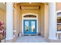 Elegant front entrance with double glass doors, stone pillars, and neutral tones, creating a welcoming ambiance at 1429 Blue Jay Ct, Punta Gorda, FL 33950