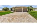 New construction home with paver driveway and landscaped lawn at 24237 San Lucas Ln, Punta Gorda, FL 33955