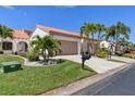 Bright, two-story home with a two-car garage, tropical landscaping and palm trees at 5081 San Rocco Ct, Punta Gorda, FL 33950