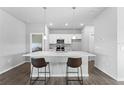 Modern kitchen with white cabinets and island with seating at 14242 Imlay Ave, Port Charlotte, FL 33981