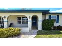 Inviting front entrance with arched entryway, teal door, and landscaping at 22260 Aburto Ln, Port Charlotte, FL 33952