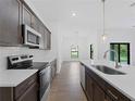 Modern kitchen with dark cabinets, white countertops and stainless steel appliances at 12550 Mohican Ave, Port Charlotte, FL 33953