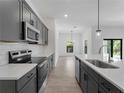 Modern kitchen with gray cabinets, stainless steel appliances, and white quartz countertops at 2795 Calabash Ln, North Port, FL 34286