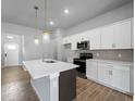 Modern kitchen with white cabinets, stainless steel appliances, granite countertops and an island with a sink at 3376 Dunbar St, Port Charlotte, FL 33948