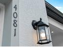 Close-up of the house number and exterior lighting fixture against a textured wall at 4081 Felhorn St, Port Charlotte, FL 33948