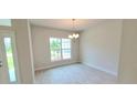 Bright dining room with tile floors and a chandelier, featuring a view of the backyard at 2536 Jacobs St, Port Charlotte, FL 33953
