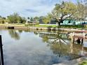 Tranquil view of canal with docks and boat lift behind a home with pool and screened-in lanai at 5731 Oakview Ln, Punta Gorda, FL 33950