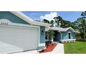 Close-up view of the home's exterior featuring a two-car garage at 2552 Jacobs St, Port Charlotte, FL 33953