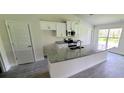 Kitchen with white cabinets, granite island and stainless steel appliances at 2552 Jacobs St, Port Charlotte, FL 33953
