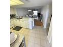 Kitchen with white cabinets, a breakfast bar, and views into the living area at 3310 Loveland Blvd # 606, Punta Gorda, FL 33980