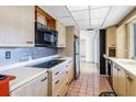 Kitchen with light wood cabinets, tiled floor, and black appliances at 2817 Coral Way, Punta Gorda, FL 33950